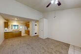 Located at 5209 Old Redwood Hwy in Wikiup, CA, this two-bedroom, one-bathroom single-floor residence offers a practical and comfortable layout. The open-concept living and dining area is a central highlight, featuring vaulted ceilings, a ceiling fan, and soft carpeting that lend the space an airy, relaxed feel. Natural light filters in through windows with views of surrounding greenery, enhancing the bright, neutral color palette throughout.

The kitchen is well-appointed with warm oak cabinetry — both upper and lower — offering generous storage, light countertops, a peninsula with bar-height seating, tile flooring, and white appliances including a range, dishwasher, refrigerator, and range hood. A window above the sink brings in natural light.

Both bedrooms are carpeted and feature vaulted or tall ceilings with ceiling fans, and windows that allow natural light. The primary bedroom is a comfortable size and is served by the full bathroom, which includes a wide vanity with oak cabinetry, a light countertop, and a large mirror. Tile flooring continues into the bathroom. The unit also includes four closets for abundant storage, a dedicated utility room, and a hallway connecting the main spaces efficiently.