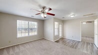 Located at 100 Kingsland Trail Loop in Kingsland, Texas, this single-story, one-bedroom, one-bathroom home offers a well-organized and efficient layout. The combined kitchen and living room serves as the heart of the home, with the kitchen featuring warm wood cabinetry, white tile countertops, a stainless steel refrigerator, an electric range, and a dishwasher. Light wood-style vinyl flooring runs throughout the kitchen area, adding a clean and modern touch. The living room transitions seamlessly from the kitchen and is carpeted, providing a comfortable atmosphere, with a ceiling fan overhead. The bedroom is a generous, well-proportioned space with soft carpeting, a ceiling fan with a light kit, a window that allows natural light and outdoor views, and two doors providing access to both the closet and the hallway. The bathroom is well-appointed with warm wood vanity cabinetry, white countertops, a large mirror, and wood-style vinyl flooring that coordinates with the kitchen. Grab bars and a medicine cabinet add practical functionality. A dedicated closet provides organized storage. Throughout the home, neutral wall tones and consistent finishes create a cohesive and inviting ambiance, making this Kingsland residence a practical and comfortable place to call home.