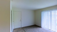 Located at 1523 E County Line Rd in Jackson, Mississippi, this single-story space offers a clean and functional layout suited for everyday living. The interior features a combination of tile and carpet flooring, with tile visible near the entryway and wall-to-wall carpeting extending through the main living area, providing a comfortable and practical surface underfoot. The walls are finished in a neutral, light tone that helps keep the space feeling open and bright. A six-panel interior door leads to an adjacent room or closet, while vertical blinds on the window allow for adjustable natural light and privacy. The ceilings are smooth and standard height, contributing to a simple, uncluttered aesthetic throughout. The overall ambiance is understated and move-in ready, offering a blank canvas that can be personalized to suit a variety of needs. The property's location on East County Line Road places it in a well-connected area of Jackson, with convenient access to local amenities, dining, and major thoroughfares throughout the metro area.