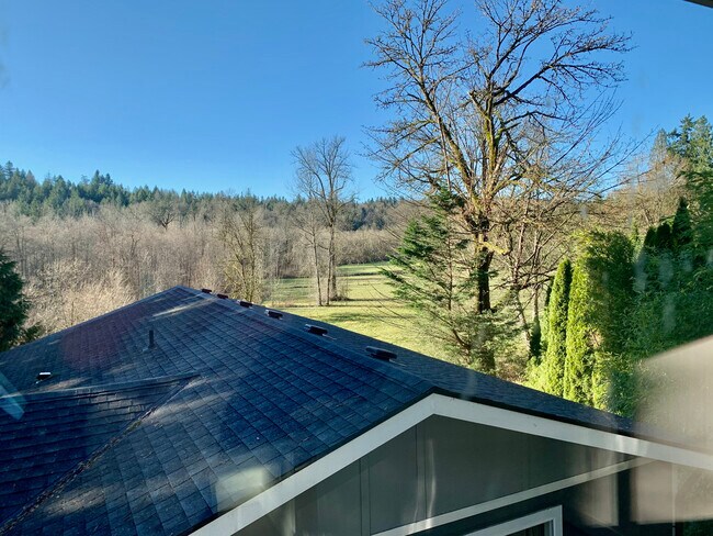 View from the bedroom window frames neighboring horse farm, beautiful greenery, and open fields - 19423 SE May Valley Rd