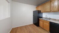 Located at 25 English Rd, Unit 109 in Manchester, New Hampshire, this two-bedroom, one-bathroom residence offers a practical and well-organized single-floor layout. The unit features a functional kitchen equipped with warm oak cabinetry, laminate wood-style flooring, a black refrigerator, electric range with overhead microwave, a tile backsplash, and laminate countertops. A peninsula-style cabinet adds additional counter space and storage. Both bedrooms are carpeted and finished with clean white walls, textured ceilings, and baseboard heating, ensuring warmth throughout the colder New England months. The primary bedroom is generously sized and includes a closet and a wall-mounted air conditioning unit for year-round climate control. Windows in each bedroom allow natural light to filter in. The second bedroom offers a comfortable and functional space, also featuring baseboard heat and a bright window. The full bathroom includes a combined tub and shower unit with a grab bar, tiled walls, and clean white fixtures. A connecting hallway ties the layout together efficiently. The unit's neutral color palette and practical finishes provide a clean, move-in ready environment suited for everyday living in Manchester, NH.
