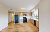 Located at 10455 Old Cutler Rd in Cutler Bay, FL, this single-floor, 3-bedroom, 2-bathroom residence offers a thoughtfully designed layout with modern finishes throughout. Light wood-tone flooring runs seamlessly across the entire unit, creating a warm and cohesive aesthetic in every room.

The open kitchen and living area serves as the heart of the home, featuring an L-shaped kitchen outfitted with flat-front wood-tone cabinetry, white countertops, a subway tile backsplash, and black appliances including a gas range, built-in microwave, refrigerator, and dishwasher. A large window over the sink fills the space with natural light and provides outdoor views.

The three bedrooms are finished with the same warm flooring and neutral wall tones, offering bright, versatile spaces. The primary bedroom includes a ceiling fan and a window with scenic outdoor views. Three closets, including walk-in wire-shelved storage, provide ample organization throughout.

The two bathrooms are finished in large-format neutral tiles. One features a glass-enclosed walk-in shower, while the other offers a soaking tub and shower combo, each with a wood-toned vanity and white countertop. Additional amenities include a dedicated laundry area and a utility room, rounding out this well-appointed residence.