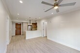 Located at 4650 Washington Ave in New Orleans, this thoughtfully designed 2-bedroom, 2-bathroom residence offers a clean, modern aesthetic throughout its single-floor layout. The open-concept living, dining, and kitchen area serves as the heart of the home, featuring light wood-look flooring, recessed lighting, and a ceiling fan that enhance the bright, airy atmosphere. The kitchen is equipped with stainless steel appliances—including a refrigerator, range, microwave, and dishwasher—complemented by light wood cabinetry, a center island with a double sink, and sleek pendant lighting overhead. Sliding glass doors in the living area open directly to a private patio, connecting indoor and outdoor living seamlessly. The spacious primary bedroom includes its own ceiling fan, recessed lighting, and an en-suite bathroom featuring a walk-in glass shower and light wood vanity. The second bedroom is equally well-appointed with natural light, a ceiling fan, and easy access to a full bathroom complete with a soaking tub, tiled surround, and matching vanity. Additional conveniences include multiple closets, in-unit laundry, and a hallway that ties the layout together efficiently. The consistent use of neutral tones and modern finishes gives the entire residence a cohesive, polished feel.