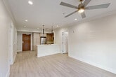 Located at 4650 Washington Ave in New Orleans, this thoughtfully designed 2-bedroom, 2-bathroom residence offers a clean, modern aesthetic throughout its single-floor layout. The open-concept living, dining, and kitchen area serves as the heart of the home, featuring light wood-look flooring, recessed lighting, and a ceiling fan that enhance the bright, airy atmosphere. The kitchen is equipped with stainless steel appliances—including a refrigerator, range, microwave, and dishwasher—complemented by light wood cabinetry, a center island with a double sink, and sleek pendant lighting overhead. Sliding glass doors in the living area open directly to a private patio, connecting indoor and outdoor living seamlessly. The spacious primary bedroom includes its own ceiling fan, recessed lighting, and an en-suite bathroom featuring a walk-in glass shower and light wood vanity. The second bedroom is equally well-appointed with natural light, a ceiling fan, and easy access to a full bathroom complete with a soaking tub, tiled surround, and matching vanity. Additional conveniences include multiple closets, in-unit laundry, and a hallway that ties the layout together efficiently. The consistent use of neutral tones and modern finishes gives the entire residence a cohesive, polished feel.