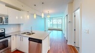 Located on the 13th floor at 1215 5th St SW in Calgary's vibrant Beltline district, this 2-bedroom, 1-bathroom unit offers a well-designed layout with an efficient use of space across a single floor. Rich hardwood flooring flows throughout the living areas and bedrooms, adding warmth to the contemporary interior.

The open-concept kitchen is a standout feature, equipped with stainless steel appliances including a refrigerator, microwave, and dishwasher. Glossy white cabinetry pairs with stone countertops and a peninsula island featuring a double undermount sink. Stylish pendant lighting illuminates the space, which opens directly into the living area.

The living area is bathed in natural light through expansive floor-to-ceiling windows that frame impressive views of the Calgary downtown skyline, including the iconic Calgary Tower. A sliding glass door leads to a private balcony.

The primary bedroom is a comfortable size and benefits from large corner windows offering continued city views. The second bedroom is well-proportioned and equally bright. The bathroom is finished with clean, modern fixtures, featuring a wood-toned vanity with stone countertop, a large mirror, tile flooring, and a tiled tub-shower surround. The unit's bright, neutral palette and modern finishes create a cohesive and functional urban living space.