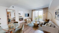 Located in Pompano Beach, FL, this well-appointed two-bedroom, two-bathroom residence offers a thoughtfully designed open-concept layout with contemporary finishes throughout. The living and dining area is anchored by warm wood-look flooring, large sliding glass doors that flood the space with natural light, and direct access to a private balcony overlooking the surrounding neighborhood. The kitchen features a clean, modern aesthetic with white upper cabinetry, light wood lower cabinets, white quartz countertops, a subway tile backsplash, and stainless steel appliances, including a dishwasher, range, and microwave. The spacious primary bedroom is finished with plush carpet, generous closet space with built-in wire shelving, and a window dressed with sheer curtains. The second bedroom mirrors this comfortable style with carpet flooring, natural light, and ample room. Both bathrooms are finished with large-format light tile flooring, white vanities with quartz countertops, and tub-shower combinations with tiled surrounds. The overall ambiance is bright, clean, and contemporary, offering a welcoming living environment with a cohesive neutral palette throughout.
