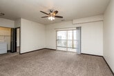 Located at 150 Rapids Square in Waterloo, Iowa, this well-appointed 2-bedroom, 1-bathroom residence offers a thoughtfully designed single-floor layout with a clean, modern aesthetic throughout. The open-concept kitchen and living area forms the heart of the home, where rich dark cabinetry with granite-style countertops pairs with wood-look tile flooring and black appliances — including a refrigerator, range, and dishwasher — to create a functional and stylish culinary space. The living area flows naturally from the kitchen, featuring plush carpeting, a ceiling fan with integrated lighting, and a sliding glass door that opens onto a private balcony with outdoor views. Both bedrooms are comfortably sized and carpeted, offering neutral tones and dark-trimmed doors. The primary bedroom is generously proportioned and includes a dedicated closet, while the second bedroom features a bright window with garden views. Four closets throughout the home provide ample storage. The full bathroom includes a vanity with dark cabinetry, a tub-shower combo, and wood-look tile flooring. A dedicated in-unit laundry room with a full-size washer and dryer adds everyday convenience. The space is finished with consistent dark baseboards and door trim, giving the interior a cohesive, polished look.