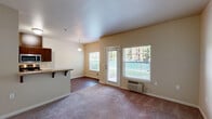 Located at 3517 Hill St SE in Albany, Oregon, this one-bedroom, one-bathroom unit offers a thoughtfully designed single-floor layout that makes efficient use of its space. The kitchen is outfitted with rich dark-wood cabinetry extending to the upper walls for ample storage, stainless steel appliances including a refrigerator, electric range, and microwave, and light-toned countertops. Wood-style laminate flooring runs throughout the kitchen and into the adjoining dining area, which is brightened by a large window with outdoor views and accented by a pendant light fixture overhead. The bedroom is carpeted and generously sized, featuring a window that brings in natural light and a double-door closet providing substantial storage. The bathroom is finished with large-format tile flooring, a dark-wood vanity with a stone-topped sink, and a full tub-shower combination. A standout feature of this unit is the in-unit washer and dryer, conveniently located within the bathroom. Neutral wall tones and clean finishes throughout create a cohesive, move-in-ready ambiance suited for comfortable everyday living.