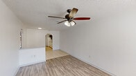 Located at 1938 SW 31st Ave in Ocala, Florida, this single-story, 2-bedroom, 2-bathroom home offers a practical and comfortable layout across a well-utilized floor plan. The living room welcomes you with wood-look laminate flooring, a textured ceiling, and a ceiling fan with integrated lighting. Natural light filters in through a front-facing window, creating a bright and airy atmosphere. An arched passageway connects the living area to the kitchen, adding a subtle architectural charm.

The galley-style kitchen is equipped with granite-look countertops, dual-tone cabinetry featuring dark upper cabinets and white lower cabinets, a white refrigerator and range, and light tile flooring. A door provides direct access to the exterior.

Both bedrooms feature wood-look laminate flooring, ceiling fans with light kits, and dedicated closet space. The primary bedroom includes a sliding glass door that opens to a fenced outdoor area, offering a private retreat. The second bedroom benefits from a natural light-filled window with blinds.

The two bathrooms are functional and clean, each featuring a tub-shower combination and brushed nickel hardware. A hallway connects all rooms, ensuring an efficient flow throughout the home. Ceiling fans are present in every primary living space, supporting comfort in Florida's warm climate.