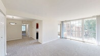 Located at 3900 Blackburn Ln, Unit 32, in Burtonsville, MD, this single-floor, 2-bedroom, 2-bathroom residence offers a practical and comfortable layout. The living room is generously sized, featuring neutral carpet flooring and a large sliding glass door that floods the space with natural light and provides views of the surrounding greenery. Adjacent to the living area, the galley-style kitchen is well-appointed with rich, dark cherry wood cabinetry, granite-style countertops, a stainless steel sink, and black appliances including a gas range and refrigerator. Light wood-look flooring runs throughout the kitchen, enhancing the clean, functional aesthetic. A window at the end of the kitchen allows for additional natural light. Both bedrooms are comfortably proportioned, with plush carpet flooring and windows that bring in natural light. The primary bedroom includes access to a closet, while the secondary bedroom offers a bright, open feel. The two bathrooms are finished with light-toned walls, wood-look flooring, and rich cherry wood vanities with brushed nickel hardware. One bathroom features a tub/shower combination with tile surround, while the other includes accessibility grab bars. A hallway and dedicated closet complete the efficient floor plan.