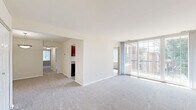 Located at 3900 Blackburn Ln, Unit 32, in Burtonsville, MD, this single-floor, 2-bedroom, 2-bathroom residence offers a practical and comfortable layout. The living room is generously sized, featuring neutral carpet flooring and a large sliding glass door that floods the space with natural light and provides views of the surrounding greenery. Adjacent to the living area, the galley-style kitchen is well-appointed with rich, dark cherry wood cabinetry, granite-style countertops, a stainless steel sink, and black appliances including a gas range and refrigerator. Light wood-look flooring runs throughout the kitchen, enhancing the clean, functional aesthetic. A window at the end of the kitchen allows for additional natural light. Both bedrooms are comfortably proportioned, with plush carpet flooring and windows that bring in natural light. The primary bedroom includes access to a closet, while the secondary bedroom offers a bright, open feel. The two bathrooms are finished with light-toned walls, wood-look flooring, and rich cherry wood vanities with brushed nickel hardware. One bathroom features a tub/shower combination with tile surround, while the other includes accessibility grab bars. A hallway and dedicated closet complete the efficient floor plan.