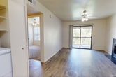 Located at 2601 E McKellips Rd in Mesa, AZ, this 510-square-foot, one-bedroom, one-bathroom apartment is thoughtfully designed to maximize every inch of its single-floor layout. The combined kitchen and living area serves as the heart of the unit, featuring wood-look plank flooring that extends throughout the main living spaces, lending a clean and cohesive aesthetic. The living room is brightened by a ceiling fan with integrated lighting and a sliding glass door that opens to a private balcony, offering pleasant outdoor views and abundant natural light. The kitchen is equipped with oak-toned cabinetry, dark granite-style countertops, a white electric range, and a full-size refrigerator, with a skylight adding additional brightness to the space. A hallway connects the main living area to the private bedroom, which measures 150 square feet and is finished with plush carpeting, a ceiling fan, a closet, and a window for natural light. The bathroom features a full-size tub and shower combo with a white surround, wood-look flooring, and a vanity with matching cabinetry and dark countertops. This apartment provides a practical and comfortable living space in a convenient Mesa location.