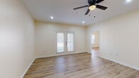 This single-floor, 2-bedroom, 2-bathroom home in Millington, Tennessee offers a clean, modern aesthetic with a thoughtfully designed open layout. Light-toned hardwood-style flooring runs throughout the entire home, creating a seamless and cohesive look from room to room.

The living area is bright and welcoming, featuring recessed lighting, a ceiling fan, and French doors that invite natural light and provide outdoor access. An open pass-through connects the living space to the kitchen, which is outfitted with crisp white shaker-style cabinetry, light stone countertops, a white subway tile backsplash, and stainless steel appliances including a range, microwave, and dishwasher.

Both bedrooms are generously sized, each featuring ceiling fans and ample natural light. One bedroom includes a walk-in closet, while the other offers convenient access to an en-suite bathroom. The second bedroom benefits from a large window with views to the outside.

The two bathrooms maintain the home's clean, contemporary style with white vanities, stone-look countertops, large mirrors, and chrome fixtures. One bathroom includes a full soaking tub with a shower surround. A long hallway connects the main living areas to the bedrooms, reinforcing the home's efficient and functional floor plan. Overall, the space presents a bright, move-in-ready environment with consistent modern finishes throughout.