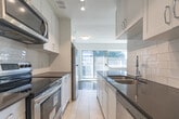 Located at 4900 Bathurst Street in Toronto's North York neighbourhood, this two-bedroom, one-bathroom unit offers a clean, functional layout across a single floor. The open-concept living and dining area is a standout feature, showcasing classic parquet wood flooring that runs throughout, large sliding glass doors, and expansive windows that flood the space with natural light while providing views of the surrounding neighbourhood. A baseboard heating system ensures year-round comfort in the living area.

The galley-style kitchen is efficiently designed with white cabinetry, a subway tile backsplash, dark countertops, stainless steel appliances including a full-size refrigerator and stove, and tile flooring. A pass-through counter connects the kitchen to the living area, enhancing the sense of openness.

Both bedrooms feature the same warm parquet flooring, large windows with natural light, and classic radiator heating units. The primary bedroom is generously proportioned and includes a pair of mirrored sliding-door closets that add depth and storage. The second bedroom is well-sized with its own window and radiator.

The bathroom is finished with full white subway tile surrounds, a soaking tub, and a clean, bright aesthetic complemented by a frosted window. A dedicated hallway connects all areas of the unit, providing a practical and organized flow throughout.