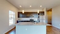 This contemporary 1,130 square foot apartment in Verona, Wisconsin offers a blend of style and functionality. The open-concept design seamlessly integrates the living room and kitchen, creating an expansive feel. The gourmet kitchen is a standout feature, boasting sleek dark cabinetry, granite countertops, and stainless steel appliances, including a built-in microwave.

Large windows throughout allow for abundant natural light, while ceiling fans in the bedrooms provide comfort and air circulation. The primary bedroom, measuring 180 square feet, offers ample space. Both bathrooms feature modern fixtures, with one showcasing a walk-in shower.

The flooring varies between plush carpeting in the bedrooms and stylish wood-look flooring in the main living areas, adding warmth and durability. Each bedroom is equipped with a closet for storage, and an additional closet space enhances the apartment's organization potential.

A sliding glass door leads to an outdoor space, perfect for enjoying fresh air or potential views. The neutral color palette throughout allows for versatile decorating options. This well-designed apartment combines modern amenities with practical living spaces, making it an attractive option for those seeking a contemporary lifestyle in Verona.