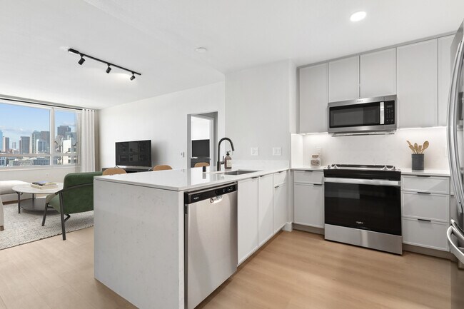 Cocina y sala de estar Signature Collection Fase I con pisos de superficie dura. - Avalon at Mission Bay