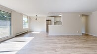 Located at 1126 Adelaide St N in London, Ontario, this well-appointed 2-bedroom, 1-bathroom unit offers a thoughtfully designed layout across a single floor. Light wood laminate flooring runs throughout, creating a warm and cohesive aesthetic in every room. The open-concept living and dining area is bathed in natural light from large windows and a sliding glass door that leads to a private balcony with outdoor views of surrounding greenery. The kitchen features white cabinetry with black hardware, dark marble-style countertops, stainless steel appliances including a full-size refrigerator, and a peninsula breakfast bar that connects seamlessly to the living space — ideal for both everyday use and entertaining. A dedicated entrance and hallway provide practical flow through the unit. Both bedrooms are generously sized, with the primary bedroom offering ample space and access to one of four closets, several of which include built-in shelving for organized storage. The bathroom is finished with a full tub-shower combination featuring clean white tile surround accented by a warm tan tile border. Baseboard heating is present throughout, and the overall palette of neutral whites and soft beiges gives the space a clean, move-in-ready feel.