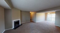 Located on Patchen in Lexington, Kentucky's 40517 zip code, this single-floor home offers a practical and comfortable layout across a well-organized floor plan. The spacious living area is a standout feature, showcasing a classic wood-burning fireplace with a clean white mantle and dark surround, set against neutral taupe walls and plush wall-to-wall carpeting. The living space flows openly into a separate dining area illuminated by natural light from large vertical-blind-covered windows and a ceiling fan. The kitchen is outfitted with dark cabinetry, white countertops, tile flooring, and a stainless steel electric range with an over-range microwave, offering a functional and modern cooking space. Multiple bedrooms feature soft carpeting, neutral painted walls, textured ceilings, and windows with blinds that bring in natural light. One bedroom notably includes two bifold-door closets, providing generous storage. The full bathroom is finished with tile flooring, a tub-shower combination, and a wall-mounted mirror. Consistent neutral tones and carpeted floors throughout lend the home a cohesive, move-in-ready feel.