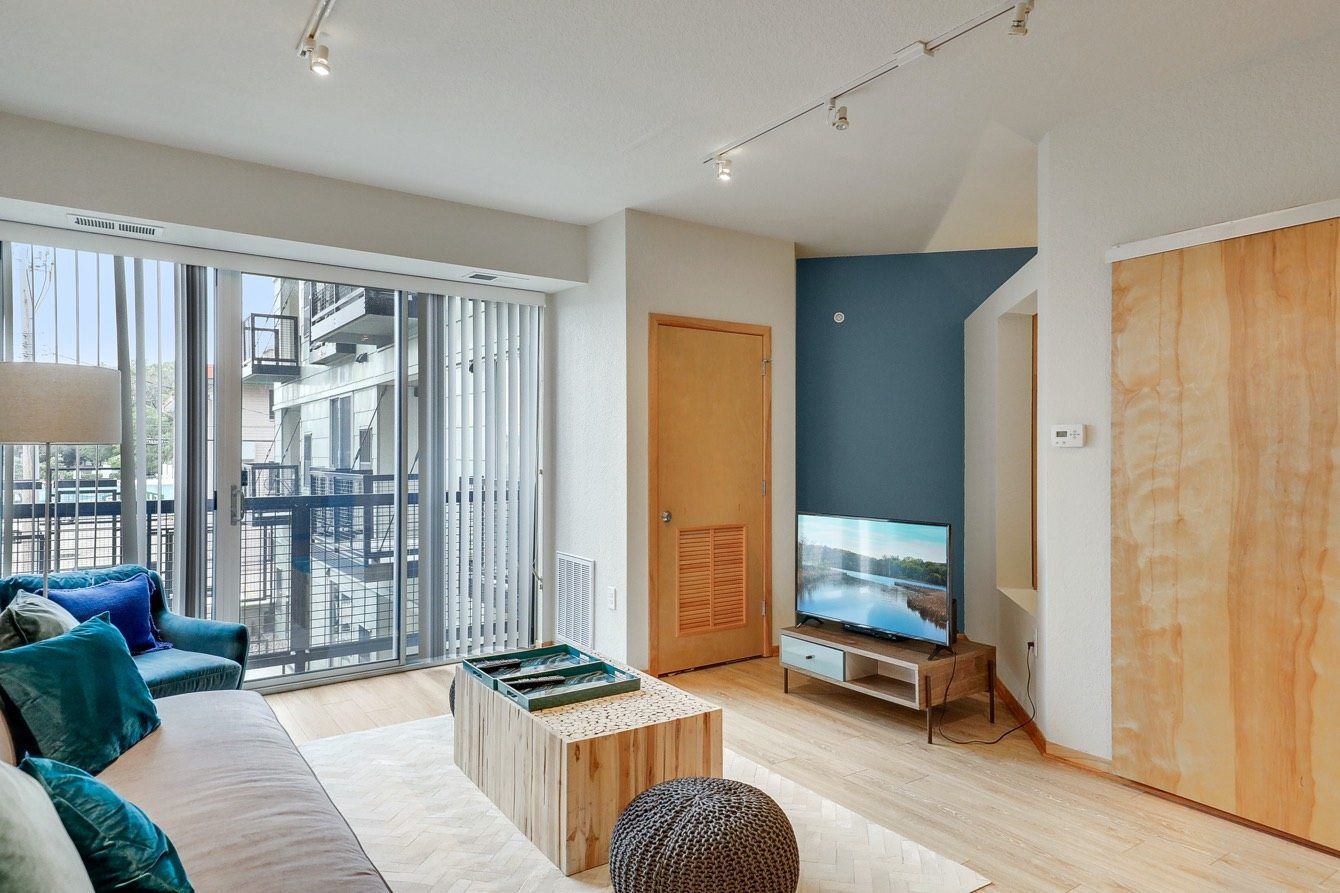 Living room with a sofa, armchair, coffee table, and TV.