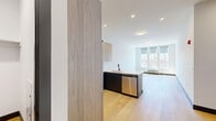 Located at 188 Broadway in Woodcliff Lake, NJ, this well-designed two-bedroom, three-bathroom residence offers a thoughtfully planned single-floor layout with modern finishes throughout. Light hardwood flooring runs continuously through the living areas, bedrooms, and hallways, complemented by crisp white walls and dark baseboards that create a clean, contemporary aesthetic.

The open-concept kitchen is a standout feature, showcasing warm wood-grain upper cabinetry, dark lower cabinets, and a white quartz peninsula with an undermount sink and matte black faucet. Stainless steel appliances, including a side-by-side refrigerator, electric range, and built-in microwave, complete the space. Recessed lighting enhances the bright, functional atmosphere.

The generously sized primary bedroom features a bank of large windows with scenic outdoor views and ample natural light, along with dedicated closet space featuring built-in shelving and dual hanging rods. The second bedroom is similarly bright and well-proportioned.

The bathrooms are finished to a high standard, featuring frameless glass enclosures with matte black hardware, tiled walk-in showers, and a tub-shower combination. A well-lit hallway connects all rooms efficiently, and four closets provide abundant storage throughout the residence.