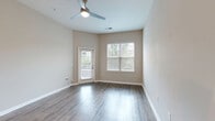 Located at 15708 Greythorne Dr in Charlotte, NC, this one-bedroom, one-bathroom home offers a well-designed single-floor layout with a thoughtful mix of comfort and modern finishes. The living room is bright and welcoming, featuring wood-style flooring, neutral warm-toned walls, a ceiling fan with light fixture, and dual windows with blinds that invite natural light. A glass-paned door provides direct access to a private balcony with outdoor views of the surrounding neighborhood. The kitchen is efficiently laid out with light wood cabinetry, white quartz-style countertops, a subway tile backsplash, and a full suite of stainless steel appliances including a refrigerator, range, and built-in microwave. A dedicated laundry area and hallway connecting the rooms add practical convenience. The bedroom is generously sized, finished with plush wall-to-wall carpeting, a ceiling fan, and a window that provides natural light. Two closets offer ample storage. The bathroom includes wood-look tile flooring, a granite-topped vanity, and a walk-in glass-door shower accented with a decorative mosaic tile border. Clean lines and a neutral color palette throughout give the home a cohesive, move-in-ready feel.