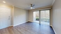 This well-appointed 2-bedroom, 1-bathroom residence in Lakeland, Florida offers a thoughtfully designed single-floor layout with a functional and comfortable living environment. The open-concept living room and kitchen area serve as the heart of the home, featuring wood-style plank flooring, recessed lighting, and crown molding. A breakfast bar peninsula connects the living space to the kitchen, which is outfitted with gray shaker-style cabinetry, quartz countertops, stainless steel appliances including a range and refrigerator, and an over-range microwave. A sliding glass door in the living room fills the space with natural light and provides views of the lush outdoor greenery. Both bedrooms are carpeted and equipped with ceiling fans, large windows with blinds that invite natural light, and access to dedicated closets. The primary bedroom includes a spacious walk-in closet with wire shelving systems offering generous storage capacity. The bathroom features a full soaking tub and shower combination with tile surround and wood-style flooring. A connecting hallway links the bedrooms and bathroom with ease. Neutral warm-toned walls throughout the home create a clean, cohesive aesthetic ideal for a variety of furnishing styles.
