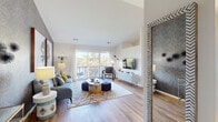This thoughtfully designed single-floor residence blends contemporary style with comfortable living across a well-organized layout. The living room serves as the heart of the home, showcasing warm hardwood-style flooring, vaulted ceilings, and a striking geometric-patterned accent wall. Large sliding glass doors flood the space with natural light and open directly onto a private balcony with serene waterfront views, creating a seamless indoor-outdoor connection. A dedicated dining area sits adjacent to the living space, featuring a window with garden views and ample room for entertaining. The galley-style kitchen is outfitted with white cabinetry, granite-style countertops, and stainless steel appliances, offering an efficient and clean workspace. The bedroom is a calm retreat, highlighted by a bold diamond-patterned wallpaper accent wall, plush carpeting, and a bright window. The full bathroom includes a tub-shower combination, a wide vanity with granite-style countertops, and wood-style flooring. A dedicated laundry area with a full-size washer and dryer, built-in shelving, and generous storage rounds out the functional amenities of this well-appointed residence.