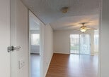 Located at 3505 W Atlantic Blvd in Pompano Beach, Florida, this single-floor unit offers a well-organized layout designed for comfortable everyday living. The interior is finished with warm wood-look laminate flooring that runs throughout the main living areas and bedrooms, complemented by neutral-toned walls and textured ceilings. Ceiling fans are installed in the living room and bedrooms, providing year-round comfort. The open living area is bright and welcoming, featuring a sliding glass door with vertical blinds that allows natural light to pour in and provides access to the outdoors. A pass-through counter connects the living space to the galley-style kitchen, which is equipped with white cabinetry, a double sink, a range, dishwasher, and refrigerator, offering ample storage and functionality. The bedrooms are generously sized, each featuring wood-look flooring, ceiling fans, and windows dressed with vertical blinds that frame views of the surrounding greenery. The bathroom includes a wide vanity with a large mirror, a medicine cabinet, and a tub-shower combination. A dedicated in-unit laundry area accommodates a full-size washer and dryer side by side, complete with overhead shelving for added storage convenience.