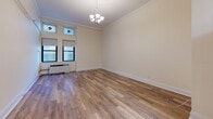 Located on Boylston Street in the heart of Boston, MA, this single-floor unit offers a thoughtfully designed living space with a blend of classic and contemporary finishes. The main living area features warm hardwood-style flooring, crisp white crown molding, and an elegant chandelier that adds a touch of sophistication. A set of windows, accented by decorative stained glass transoms, allows natural light to fill the room, creating a bright and welcoming atmosphere. A wall-mounted rail system provides practical storage potential throughout the space. The kitchen is efficiently outfitted with rich dark wood cabinetry, granite countertops, a subway tile backsplash, and stainless steel appliances including an electric range with overhead ventilation and a full-size refrigerator. The bathroom showcases a classic black-and-white mosaic tile floor, white subway wall tiles with dark accent trim, a combined tub and shower enclosed by sliding glass doors, and a dark wood vanity topped with granite. Together, these elements create a cohesive and functional living environment well-suited to urban Boston living.