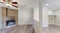 Located at 1500 N Carlsbad Trace in Fayetteville, Arkansas, this two-bedroom, one-bathroom single-story home offers a functional and comfortable layout with thoughtful finishes throughout. The living room serves as the heart of the home, anchored by a striking floor-to-ceiling brick corner fireplace and complemented by a ceiling fan overhead and light luxury vinyl plank flooring that extends throughout the main living areas. A half-wall partition subtly separates the entry area from the living space, adding architectural character. The kitchen features an L-shaped layout with crisp white shaker-style cabinetry, granite-look countertops, a stainless sink beneath a natural light window, and black appliances including a range, dishwasher, and refrigerator. Light LVP flooring continues here, maintaining a cohesive flow. The primary bedroom is generously sized, offering plush carpeting, a ceiling fan, and a closet with built-in shelving. The second bedroom is equally comfortable with soft carpet, a ceiling fan, a window, and direct access to the exterior. The bathroom includes a full tub/shower combination, a white vanity with granite-look countertop, and LVP flooring. A dedicated laundry nook with washer/dryer hookups adds everyday convenience. Textured ceilings are present throughout.
