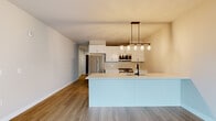 Located at 932 Maple Ave in Downers Grove, IL, this thoughtfully designed single-floor residence offers a clean, modern aesthetic throughout. The open-concept kitchen is a standout feature, showcasing white shaker cabinetry with matte black hardware, bright white countertops, a large center island with an undermount sink and stylish black faucet, and a full suite of stainless steel appliances including a gas range, built-in microwave, refrigerator, and dishwasher. Pendant lighting with Edison-style bulbs adds warmth above the island. The kitchen flows naturally into the living area, which is finished with warm wood-tone luxury vinyl plank flooring and neutral walls that create a bright, airy atmosphere. Bedrooms are carpeted for comfort and feature warm taupe tones, with one bedroom offering a stylish sliding barn door and ceiling fan. A sliding glass door in one room opens to a private balcony, inviting natural light and outdoor views. The bathroom is finished with white cabinetry, a white countertop vanity, a large framed mirror, and wood-tone flooring, maintaining the cohesive modern palette found throughout the space. Clean lines, neutral finishes, and functional design define this well-appointed residence.