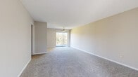 This single-floor, 2-bedroom, 2-bathroom unit offers a practical and comfortable layout designed to maximize everyday living. The spacious living room serves as the heart of the home, featuring soft carpeting, neutral beige walls, and a ceiling fan overhead. A sliding glass door opens to a private balcony, allowing natural light to fill the room and providing pleasant outdoor views of surrounding greenery.

The kitchen is well-equipped with white cabinetry, light countertops, and black appliances including a range, dishwasher, and refrigerator. A window above the sink brings in additional natural light, and durable wood-look flooring adds a clean, modern touch to the space.

The primary bedroom is generously sized, offering ample room for furnishings, and includes carpeted flooring and a window with natural light. The second bedroom is similarly appointed, with carpet and a window overlooking the outdoors. A dedicated closet adds to the unit's storage capacity.

Both bathrooms are functional and well-maintained. One features a vanity with white cabinetry and a lighted mirror, while the other includes a full tub-shower combination with white subway tile surround. Wood-look flooring in the bathrooms adds a cohesive design element throughout. A hallway and entrance area complete the efficient and thoughtfully organized floor plan.