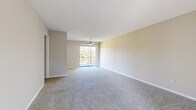 This single-floor, 2-bedroom, 2-bathroom unit offers a practical and comfortable layout designed to maximize everyday living. The spacious living room serves as the heart of the home, featuring soft carpeting, neutral beige walls, and a ceiling fan overhead. A sliding glass door opens to a private balcony, allowing natural light to fill the room and providing pleasant outdoor views of surrounding greenery.

The kitchen is well-equipped with white cabinetry, light countertops, and black appliances including a range, dishwasher, and refrigerator. A window above the sink brings in additional natural light, and durable wood-look flooring adds a clean, modern touch to the space.

The primary bedroom is generously sized, offering ample room for furnishings, and includes carpeted flooring and a window with natural light. The second bedroom is similarly appointed, with carpet and a window overlooking the outdoors. A dedicated closet adds to the unit's storage capacity.

Both bathrooms are functional and well-maintained. One features a vanity with white cabinetry and a lighted mirror, while the other includes a full tub-shower combination with white subway tile surround. Wood-look flooring in the bathrooms adds a cohesive design element throughout. A hallway and entrance area complete the efficient and thoughtfully organized floor plan.