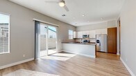 This well-designed single-story home offers three bedrooms and one bathroom within a thoughtfully arranged floor plan. Light wood-toned flooring runs consistently throughout the entire space, creating a cohesive and clean aesthetic.

The open-concept kitchen and living area serves as the heart of the home. The kitchen is equipped with stainless steel appliances, including a French door refrigerator, electric range, and built-in microwave. White upper cabinetry contrasts with warm wood-toned lower cabinets, and a peninsular island with a dark quartz-style countertop provides additional prep space and casual seating. A ceiling fan overhead and sliding glass doors leading to an outdoor patio bring natural light and airflow into the living area.

The three bedrooms feature neutral gray walls, light wood flooring, and horizontal windows that allow natural light while maintaining privacy. The primary bedroom is generously sized, while the additional bedrooms offer comfortable and flexible living space. Each room includes ceiling fixtures and recessed lighting.

The bathroom is sleek and functional, featuring warm wood-toned cabinetry with modern hardware, a quartz countertop, an undermount sink, and a glass-enclosed shower-tub combination. A frosted window provides natural light. A connecting hallway links the rooms efficiently, completing this clean and contemporary home.