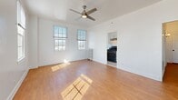 Located at 2505 W 6th St in Los Angeles, this 1-bedroom, 1-bathroom unit offers a well-organized layout across a single floor. A welcoming hallway with warm hardwood flooring and clean white walls leads into the main living areas. The spacious living room is bathed in natural light from large double-hung windows offering city views, and features a stylish ceiling fan with a brushed gold finish. Hardwood flooring extends throughout, adding warmth and continuity to the space. The combined dining and kitchen area is efficiently designed, showcasing white shaker cabinetry, dark gray countertops, a matte black faucet with an undermount sink, and stainless steel appliances including a refrigerator and gas range. The generous primary bedroom benefits from multiple windows that invite ample natural light, along with classic hardwood floors. Four closets provide substantial storage throughout the unit. The bathroom is thoughtfully finished with light wood-look flooring, classic white subway tile wainscoting, a pedestal sink, a full soaking tub with an overhead shower, and a window that brightens the room. The crisp, white interior palette throughout gives the space a clean, airy, and move-in-ready feel.
