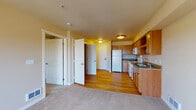 Located at 5207 West Hildebrand Boulevard in Kennewick, Washington, this single-floor residence offers a functional and comfortable layout designed for everyday living. The open-concept floor plan seamlessly connects the kitchen and living area, creating a welcoming and versatile space.

The kitchen is well-equipped with warm honey-toned wood cabinetry offering generous storage, dark laminate countertops, and white appliances including a refrigerator, electric range, built-in microwave, and dishwasher. Light hardwood flooring runs throughout the kitchen and entry areas, providing a clean, bright aesthetic that transitions smoothly into the carpeted living space.

The living area is open and airy, benefiting from natural light that flows in from a sliding glass door leading to a private balcony with outdoor views of the surrounding Kennewick neighborhood. Multiple interior doors lead to a hallway accessing the bedroom and bathroom, offering a well-defined separation between the living and sleeping areas.

The bedroom is a comfortable, carpeted retreat featuring a large window that fills the room with natural light and includes a wall-mounted climate control unit. The bathroom is clean and straightforward, featuring a full soaking tub with a shower surround. Throughout the unit, neutral warm tones and consistent finishes create a cohesive and inviting atmosphere.