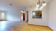 Located on Watertown Road in Waukesha, Wisconsin, this single-floor, three-bedroom, three-bathroom residence offers a functional and cohesive layout with light hardwood flooring carried consistently throughout. The open-concept living and dining area is bright and spacious, anchored by a stylish pendant chandelier and connected to the kitchen via a convenient pass-through with a granite-topped breakfast bar. The kitchen is well-appointed with warm honey-toned wood cabinetry, granite countertops, stainless steel appliances including a refrigerator and range, a built-in microwave, and a dishwasher — all complemented by a skylight that adds natural brightness. The generously sized primary bedroom features a ceiling fan, a window overlooking the outdoors, and access to a walk-in closet with wire shelving. The additional bedrooms are well-proportioned, each with natural light from windows and closet access. The bathrooms are cleanly finished, with one featuring a full tub-shower combination and a wood-trimmed vanity with an integrated sink. Five total closets throughout the home provide exceptional storage capacity. Consistent light hardwood flooring, warm wood trim accents on doors and baseboards, and neutral wall tones create a cohesive, welcoming ambiance throughout the entire residence.