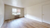 Located at 846 Brunswick Rd in Essex, Maryland, this 2-bedroom, 1-bathroom unit offers a practical and well-organized single-floor layout. Light wood laminate flooring runs consistently throughout, lending a clean and cohesive look to the entire space.

The living room provides an open, airy feel with neutral white walls and direct sightlines to both the kitchen and hallway. The kitchen is efficiently laid out with warm oak cabinetry, a double-basin stainless steel sink, a coil-top range, a refrigerator, and a window that brings in natural light. A radiator unit in the kitchen maintains consistent warmth.

Both bedrooms are well-proportioned, featuring neutral walls, light wood flooring, and windows fitted with roller shades. The primary bedroom is notably spacious and benefits from dual windows, allowing ample natural light and outdoor views. Classic cast-iron radiators are present in both bedrooms, providing reliable radiant heating. Wall-mounted sconce lighting adds a functional touch to the secondary bedroom.

The bathroom includes a full tub-shower combination with white tile surround, a window for natural light and ventilation, a toilet, and a wood-toned vanity with a white countertop. A hallway connects all rooms, contributing to an efficient and easy-to-navigate floor plan throughout the unit.