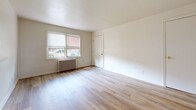 Located at 846 Brunswick Rd in Essex, Maryland, this 2-bedroom, 1-bathroom unit offers a practical and well-organized single-floor layout. Light wood laminate flooring runs consistently throughout, lending a clean and cohesive look to the entire space.

The living room provides an open, airy feel with neutral white walls and direct sightlines to both the kitchen and hallway. The kitchen is efficiently laid out with warm oak cabinetry, a double-basin stainless steel sink, a coil-top range, a refrigerator, and a window that brings in natural light. A radiator unit in the kitchen maintains consistent warmth.

Both bedrooms are well-proportioned, featuring neutral walls, light wood flooring, and windows fitted with roller shades. The primary bedroom is notably spacious and benefits from dual windows, allowing ample natural light and outdoor views. Classic cast-iron radiators are present in both bedrooms, providing reliable radiant heating. Wall-mounted sconce lighting adds a functional touch to the secondary bedroom.

The bathroom includes a full tub-shower combination with white tile surround, a window for natural light and ventilation, a toilet, and a wood-toned vanity with a white countertop. A hallway connects all rooms, contributing to an efficient and easy-to-navigate floor plan throughout the unit.