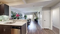 Located at 7077 Alvern St in Los Angeles, CA, this well-appointed one-bedroom, one-bathroom residence offers a thoughtfully designed single-level layout. Dark hardwood flooring flows consistently throughout the space, anchoring a cohesive and contemporary aesthetic.

The kitchen is a standout feature, outfitted with dark wood cabinetry, stainless steel appliances including a refrigerator, microwave, and gas range, a decorative tile backsplash, and a peninsula with white quartz countertops that doubles as a breakfast bar. Recessed lighting illuminates the workspace efficiently.

Adjacent to the kitchen, the dedicated dining area accommodates a full-sized dining table, making it well-suited for entertaining. The space is accented with tasteful wall art and lush greenery.

The living room is bright and inviting, benefiting from a sliding glass door that opens to an outdoor area and allows natural light to fill the room. A fireplace serves as a focal point, adding warmth and character to the space.

The primary bedroom offers a comfortable and private retreat. The bathroom features a combination tub and shower, a vanity, and hardwood-style flooring that ties in with the rest of the home. The overall ambiance throughout is modern, clean, and sophisticated.
