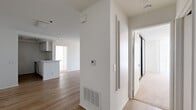 Located at 1200 N June St in the heart of Hollywood, Los Angeles, this 2-bedroom, 2-bathroom residence offers a well-designed single-level layout. The open-concept living and dining area is finished with light hardwood-style flooring and features a classic fireplace as a focal point. Floor-to-ceiling vertical blinds line the large sliding glass door, allowing abundant natural light and outdoor views to fill the space. The galley-style kitchen is efficiently laid out with white cabinetry, a gas range, stainless steel refrigerator, and a double sink — all separated from the main living area by a convenient breakfast bar. Both bedrooms are carpeted for comfort; the spacious primary bedroom includes mirrored sliding closet doors that enhance the sense of space, along with direct access to a walk-in closet. The second bedroom is generously sized with clean white walls and soft carpeting. Each bathroom is finished with wood-look flooring, white cabinetry with light countertops, and a tub-shower combination. The second bathroom features a bright window that brings in natural light. Clean, neutral finishes throughout lend the unit a versatile and move-in ready appeal.