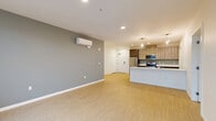 Located in Seattle's vibrant Roosevelt neighborhood, this thoughtfully designed unit offers three bedrooms, three bathrooms, and a single-floor layout that maximizes functionality and comfort. The open-concept living, dining, and kitchen area serves as the heart of the home, featuring light wood-style flooring, recessed lighting, and a wall-mounted mini-split system for efficient climate control. The sleek, modern kitchen is outfitted with stainless steel appliances including a range, microwave, and dishwasher, complemented by two-tone cabinetry, white quartz countertops, a peninsula with pendant lighting, and a dedicated pantry for added storage. Each bedroom offers a bright, airy atmosphere with large windows that bring in natural light and urban views. The primary bedroom includes its own ensuite bathroom. The bathrooms are finished in a contemporary style, featuring floating vanities with dark countertops, glass-enclosed walk-in showers, and wood-toned tile flooring. Storage is well-addressed throughout, with five closets including a spacious walk-in fitted with wire shelving systems. Clean lines, neutral tones, and modern finishes give this unit a cohesive, polished character throughout.
