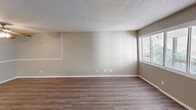 This 2-bedroom, 2-bathroom residence in Columbia, SC offers a thoughtfully laid-out single-floor design with a clean, neutral color palette throughout. The open living area features wood-look plank flooring, textured ceilings, and a large window that brings in natural light, creating a bright and welcoming atmosphere. The galley-style kitchen is well-equipped with ample white cabinetry, marble-look countertops, a double sink, and white appliances including a full-size refrigerator. A ceiling fan in the adjacent dining area adds comfort and airflow. A hallway connects the living spaces to the private quarters, where both bedrooms feature plush carpet flooring, neutral walls, and windows with natural light. The primary bedroom offers a generous footprint with a sliding-door closet for storage. Both bathrooms are finished with marble-look vanity countertops, mirrored medicine cabinets, and overhead lighting. One bathroom includes a full tub-shower combo with white tile surround and wood-look flooring. The consistent use of neutral tones and practical finishes throughout gives this residence a clean, move-in-ready appeal suitable for everyday living.