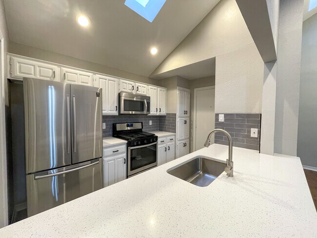 Quartz countertops in the kitchen along with all new stainless steel appliances, featuring a gas oven range, vented microwave, French door refrigerator with built ice maker, dishwasher and garbage disposal. you will love the vaulted ceiling and tons of natural light from the skylights! - 812 Via Madonna