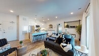Located at 15 Poplar St in Glassboro, NJ, this single-floor residence offers a thoughtfully designed open-concept layout that seamlessly connects the living, dining, and kitchen areas. Rich hardwood-style flooring runs throughout the main living space, complemented by recessed lighting and neutral white walls that create a bright, welcoming atmosphere. A sliding glass door in the living area provides natural light and outdoor access.

The kitchen is a standout feature, boasting white shaker-style cabinetry, granite countertops, a subway tile backsplash, stainless steel appliances — including a range, microwave, and dishwasher — and a large center island with bar seating. Rustic open shelving adds both function and character to the space.

The primary bedroom is generously proportioned, featuring multiple windows that flood the room with natural light, while a second bedroom offers a cozy, well-designed layout with ample closet space and frosted double doors.

The bathroom is elegantly finished with granite countertops, white cabinetry, a glass-enclosed shower, and tile flooring. A barn-style sliding door adds a modern architectural detail to the interior. Overall, this residence combines contemporary finishes with a functional, open floor plan suited for comfortable everyday living.