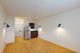 Located at 200 Pinnacle Parkway in Covington, Louisiana, this efficiently designed one-bedroom, one-bathroom unit makes smart use of its intimate footprint. The main living area seamlessly combines the living room, dining space, and kitchen into a single open-concept layout, finished with warm light wood flooring throughout. The compact kitchenette is equipped with dark wood cabinetry, a stainless steel refrigerator, microwave, and a sink — all tucked neatly into one corner. Wall-mounted directional sconces provide focused accent lighting, while a TV mounting bracket on the main wall adds a functional touch. A window with blinds in the bedroom area allows natural light to filter in, brightening the clean white walls. The bedroom is a well-proportioned private retreat, also featuring light wood flooring, a wall-unit HVAC system, and ample wall space. A closet provides dedicated storage. The bathroom offers a full granite-surround soaking tub and shower combination with a safety grab bar, complemented by a granite-topped vanity with a mirror. The overall aesthetic is clean, minimal, and functional — well-suited for efficient, comfortable single-occupant living in the Covington area.
