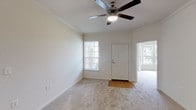 This single-floor, 3-bedroom, 2-bathroom residence offers a thoughtfully designed layout that maximizes comfort and functionality. The living area welcomes you with plush carpeting, crown molding, and a ceiling fan, creating a bright and airy atmosphere enhanced by natural light streaming through multiple windows. An adjacent space transitions seamlessly from hardwood-style flooring to carpet, connecting the living area to the rest of the home.

The kitchen is a standout feature, boasting rich dark espresso cabinetry paired with granite-style countertops and a breakfast bar. White appliances, including a range, microwave, refrigerator, and dishwasher, complement the light hardwood-style flooring, while ample cabinet storage ensures practicality.

The bedrooms are generously sized, each featuring soft carpeting, ceiling fans, and crown molding. A notable bedroom showcases a charming bay window that invites abundant natural light and offers pleasant outdoor views. The additional bedrooms provide comfortable retreats with easy hallway access.

Both bathrooms are well-appointed with dark wood vanities, granite-style countertops, and tub-shower combinations with chrome fixtures. Hardwood-style flooring adds a clean, polished finish. Throughout the home, consistent design choices in finishes and fixtures create a cohesive and inviting living environment.