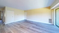 Located at 70 Lee Dr in Carnot, PA, this two-bedroom, one-bathroom residence offers a functional and well-organized single-level floor plan. The open living room is bright and inviting, featuring light wood-style flooring, soft neutral wall tones, a chandelier, and a sliding glass door that welcomes natural light. A pass-through window connects the living area to the kitchen, enhancing the open feel between spaces. The kitchen is well-appointed with dark espresso cabinetry, granite-style countertops, stainless steel appliances including a dishwasher and refrigerator, and matching light wood flooring, creating a cohesive and practical cooking space. Both bedrooms feature plush wall-to-wall carpeting and generous closet storage, including a bifold closet in the primary bedroom. The bedrooms are finished with the same warm, neutral palette seen throughout the home, with windows providing natural light. The bathroom includes a full tub-shower combination with tiled surround, a vanity with storage, and earthy-toned tile flooring. Overall, the space presents a clean, move-in-ready environment with consistent finishes and a comfortable, practical layout throughout.