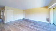 Located at 70 Lee Dr in Carnot, PA, this two-bedroom, one-bathroom residence offers a functional and well-organized single-level floor plan. The open living room is bright and inviting, featuring light wood-style flooring, soft neutral wall tones, a chandelier, and a sliding glass door that welcomes natural light. A pass-through window connects the living area to the kitchen, enhancing the open feel between spaces. The kitchen is well-appointed with dark espresso cabinetry, granite-style countertops, stainless steel appliances including a dishwasher and refrigerator, and matching light wood flooring, creating a cohesive and practical cooking space. Both bedrooms feature plush wall-to-wall carpeting and generous closet storage, including a bifold closet in the primary bedroom. The bedrooms are finished with the same warm, neutral palette seen throughout the home, with windows providing natural light. The bathroom includes a full tub-shower combination with tiled surround, a vanity with storage, and earthy-toned tile flooring. Overall, the space presents a clean, move-in-ready environment with consistent finishes and a comfortable, practical layout throughout.