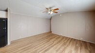 Located at 200 Logan Dr in Phenix City, Alabama, this single-floor, 3-bedroom, 2-bathroom home offers a functional and well-appointed layout throughout. Light wood-look flooring flows continuously across the entire home, creating a cohesive and clean aesthetic in every room.

The open-concept kitchen and living area serves as the heart of the home. The kitchen is equipped with white shaker-style cabinetry, a striking stacked stone tile backsplash, black appliances including a range, over-the-range microwave, and refrigerator, along with ample counter and storage space. A ceiling fan with integrated lighting anchors the adjoining living area, which features a textured ceiling and a window that brings in natural light.

The primary bedroom is a generously sized retreat with a vaulted ceiling, neutral-toned walls, and its own ceiling fan. Additional bedrooms offer comfortable proportions, natural light from windows, and the same wood-look flooring. One bedroom includes a closet with a wire storage rack. The two bathrooms are cleanly designed, each featuring a tub/shower combination with white tile surround, a vanity with storage cabinetry, a mirror, and wood-look flooring. The overall ambiance of the home is bright, neutral, and move-in ready.